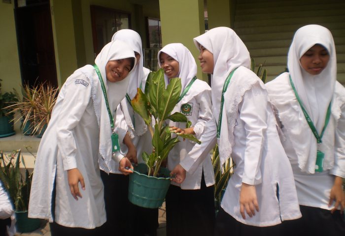 Siswa Menanam tanaman hias dalam pot di sekitar sekolah